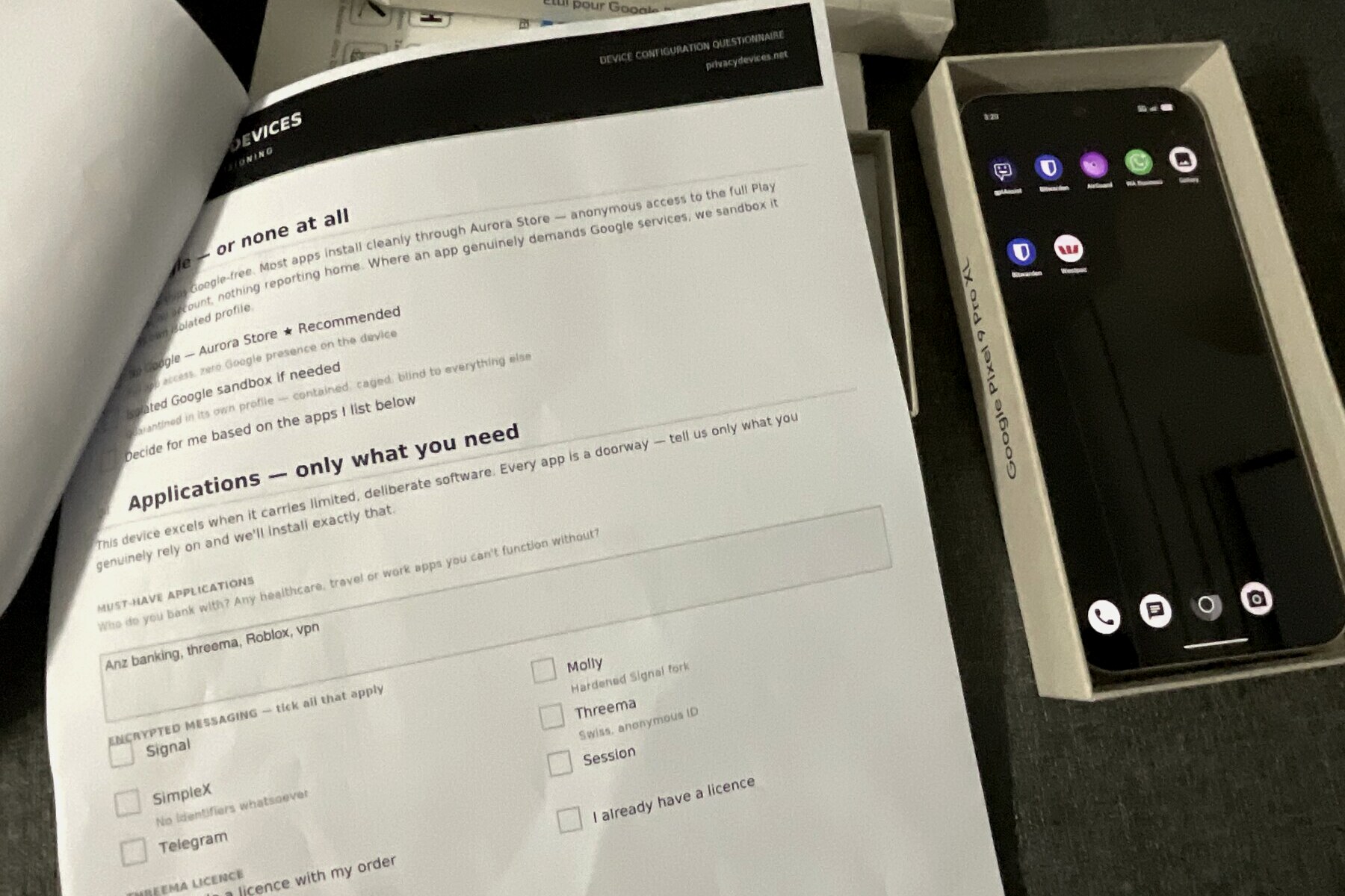 Printed Privacy Devices device-configuration questionnaire beside a configured Google Pixel